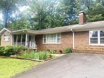Charming single-story brick home with a covered front porch and manicured front yard at 2307 Piedmont Dr, Sanford, NC 27330