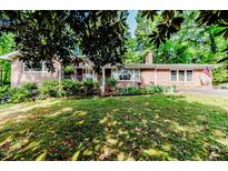 Charming brick home with a well-maintained front yard, lush landscaping and inviting porch at 2307 Piedmont Dr, Sanford, NC 27330