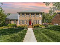 Stunning brick home with a manicured lawn, beautiful landscaping, and a welcoming red front door at 2545 Churchill Dr, Burlington, NC 27215