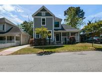 Charming two-story home with gray siding, white trim, covered porch, and mature trees at 314 Gray Ave, Durham, NC 27701