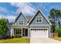 Charming two-story home featuring a well-manicured lawn, a two-car garage, and distinctive gray siding at 4412 Powell Grove Ct, Raleigh, NC 27606