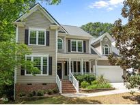 Charming home with a welcoming front porch, well-manicured landscaping, and a two-car garage at 504 Cameron Glen Dr, Apex, NC 27502
