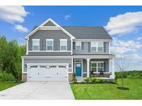 Charming two-story home with gray siding, stone accents, and a welcoming front porch at 533 Freedom Trail Dr, Willow Springs, NC 27592