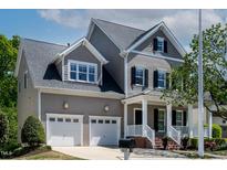 Charming two-story home featuring a two-car garage and inviting front porch with black shutters at 5605 Cary Glen Blvd, Cary, NC 27519