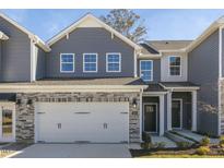 Charming two-story home with gray siding, stone accents, and a convenient attached two-car garage at 714 Andrade Dr, Fuquay Varina, NC 27526