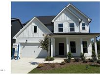 Charming two-story home with white siding, a covered porch, attached garage, and manicured lawn at 755 Bachelor Gulch Way, Apex, NC 27523