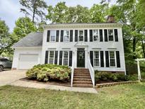 Charming two-story home with black shutters, brick stairs, manicured landscaping, and attached garage at 1002 Springmill Ct, Apex, NC 27502