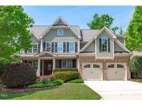 Traditional two-story home featuring a manicured lawn, attached garage, and a combination of brick and shake siding at 103 Woodland Ridge Ct, Cary, NC 27519