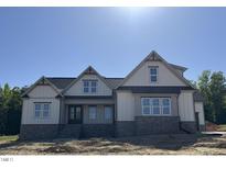 New construction home featuring stone accents, white siding, and a charming architectural design with excellent curb appeal at 1403 Cottondale Lane, Wake Forest, NC 27587