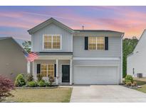 Charming two-story home featuring a well-manicured lawn, a two-car garage, and classic architectural details at 150 Sherrill Place Ln, Garner, NC 27529