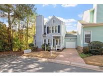 Charming two-story home with blue siding, black shutters, chimney, and well-manicured landscaping at 1601 Dunraven Dr, Raleigh, NC 27612