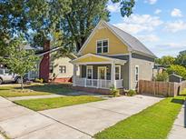 Charming home featuring a yellow and gray exterior, a welcoming front porch, and a well-maintained front yard at 215 Haywood St, Raleigh, NC 27601