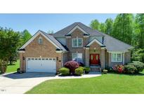 Charming brick home featuring a well-manicured lawn, mature landscaping, and a two-car garage at 226 Marshview Cir, Angier, NC 27501