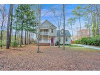 Charming two-story home featuring double balconies, a welcoming red door, and a beautifully landscaped yard at 2418 Mont Haven Dr, Durham, NC 27712