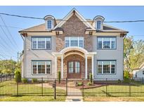 Stately two-story home features brick accents, multiple windows, and manicured landscaping with black metal fencing at 301 Georgetown Rd, Raleigh, NC 27608
