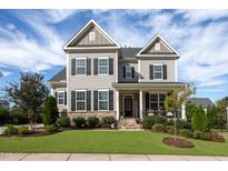 Charming two-story home with a beautifully landscaped front yard and a welcoming front porch at 3209 Star Gazing Ct, Wake Forest, NC 27587