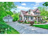 Charming two-story home with a well-manicured lawn, colorful flower beds, and a detached garage at 3581 Boulder Ct, Wake Forest, NC 27587