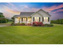 Charming one-story home featuring a covered front porch, black shutters, and a well-manicured lawn at 40 Senter Farm Ct, Fuquay Varina, NC 27526