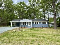 Charming single-story home with a painted brick facade, covered parking, and well-maintained front yard at 42 S 2Nd St, Roxboro, NC 27573