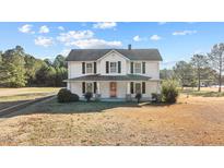 Charming white two-story farmhouse with a covered front porch and classic black shutters at 4208 Louisbury Rd, Wake Forest, NC 27587