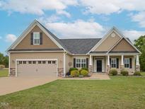 Charming single Gathering home featuring a manicured lawn, two car garage, and inviting front entrance at 63 Whistling Duck Way, Wendell, NC 27591
