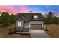 Charming new construction home featuring stone accents, a two-car garage, and a welcoming teal front door at 65 Leisure Ln # 6, Louisburg, NC 27549