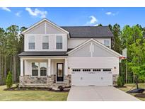 Charming two-story home featuring stone accents, a two-car garage, and a welcoming front porch at 67 Comfort Ct, Fuquay Varina, NC 27526
