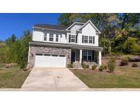 Charming two-story home featuring stone accents, a two-car garage, a well-maintained lawn and covered porch at 705 Blue Pointe Path, Apex, NC 27523