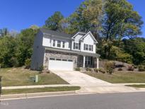 Beautiful two-story home with a stone-accented garage and a well-manicured front lawn at 705 Blue Pointe Path, Apex, NC 27523