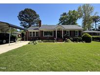 Charming brick home with a well-manicured lawn and a convenient carport at 901 Vandora Ave, Garner, NC 27529