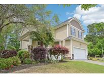 Charming two-story home with well-manicured landscaping, attached two-car garage, and inviting curb appeal at 100 Winterberry Ln, Holly Springs, NC 27540