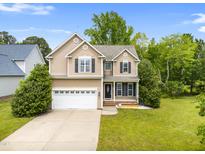 Charming two-story home with manicured lawn, two-car garage, and inviting front porch with black shutters at 11 Glen Valley Ct, Angier, NC 27501