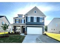 Two-story home with blue and gray siding, black shutters, a two-car garage, and a well-maintained front lawn at 1236 Cricket St, Elon, NC 27244