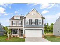 Charming two-story home features a two-car garage and a mix of neutral siding with dark shutters at 1302 Cricket St, Elon, NC 27244