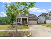 Charming home with a two-car garage, inviting front porch, and beautifully landscaped front yard at 1305 Chronicle Dr, Durham, NC 27703