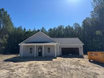 Newly constructed single-story home featuring a covered porch, attached garage, and freshly installed roof at 200 Green Pines Estates Dr, Kenly, NC 27542