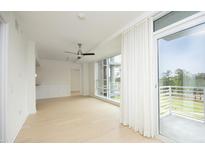 Bright, open living room featuring hardwood floors, ceiling fan, and a sliding glass door to a private balcony at 2402 Environ Way # Bldg 2000, Chapel Hill, NC 27517