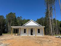 Newly constructed single story home featuring white siding and wooden support beams on the front porch at 329 Green Pines Estates Dr, Kenly, NC 27542