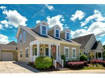 Charming two-story home featuring a welcoming front porch, dormer windows and well-manicured landscaping at 3827 Heritage Spring Circle Cir, Wake Forest, NC 27587