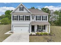 Charming two-story home featuring gray siding, black shutters, a well-manicured lawn, and an attached two-car garage at 3901 Bluffwind Dr, Raleigh, NC 27603