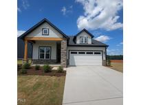 Charming home featuring stone accents, a two-car garage, and well-maintained landscaping at 40 Wabash St, Pittsboro, NC 27312