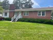 Charming brick ranch-style home with well-maintained lawn and inviting entrance at 407 N Cheatham St, Franklinton, NC 27525