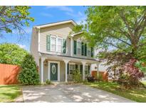 Charming two-story home featuring a welcoming front porch with classic columns and green shutters at 4125 Palafox Ct, Raleigh, NC 27604