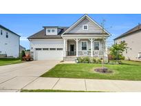 Charming home featuring a welcoming front porch and a well-maintained lawn with pretty landscaping at 4333 Benton Mill Dr, Fuquay Varina, NC 27526