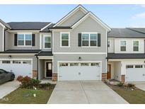 Two-story townhome featuring a two-car garage and neutral gray siding at 484 Autumn Rain St, Cary, NC 27519