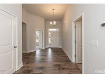 Bright entryway with hardwood flooring, a modern chandelier, and a view to a large front door at 50 Watermelon Dr, Franklinton, NC 27525