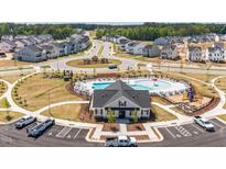 An aerial view of a neighborhood community pool, pool house, playground and parking lot at 832 Emerald Bay Cir, Raleigh, NC 27610