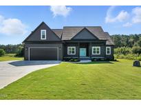 Charming single-Gathering home showcasing craftsman architecture, a two-car garage, and a bright blue front door at 8629 Dukes Lake Rd, Zebulon, NC 27597