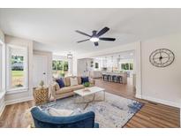 Open-concept living room featuring a modern ceiling fan and an airy kitchen with a center island at 106 Circle Dr, Mebane, NC 27302