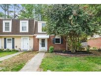 Charming townhouse featuring brick accents, dormer windows and a well maintained front yard and walkway at 13 Patriot Cir, Durham, NC 27704